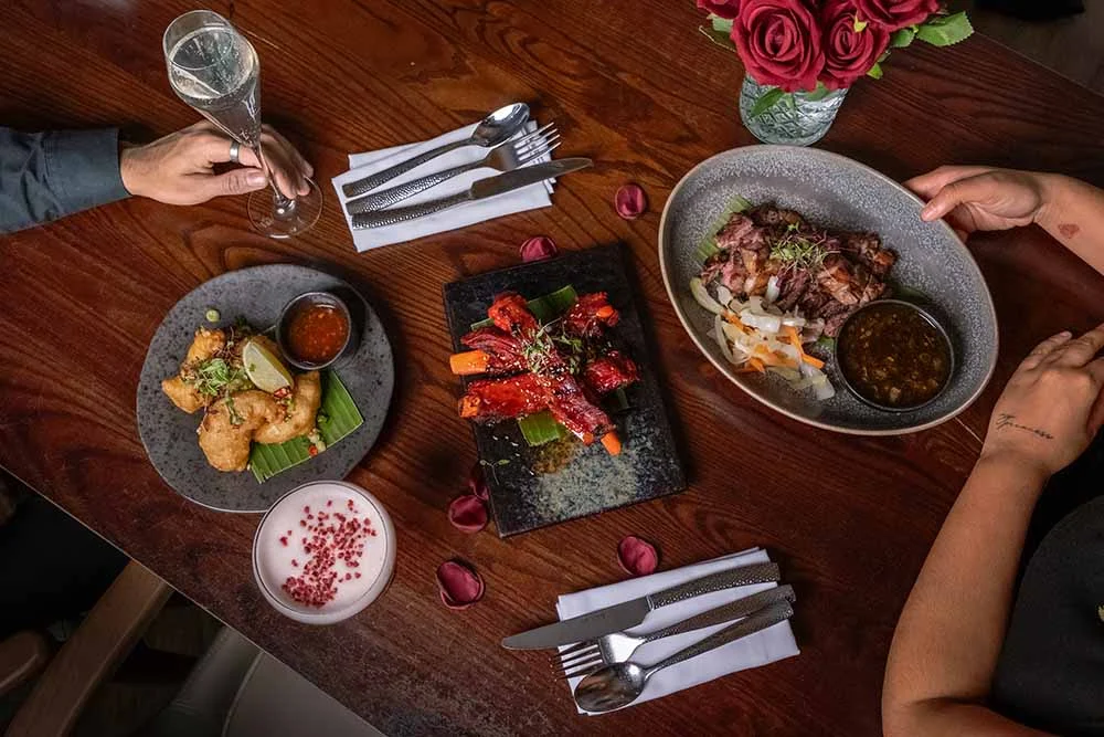 Two guests sharing starters and cocktails at Siamais